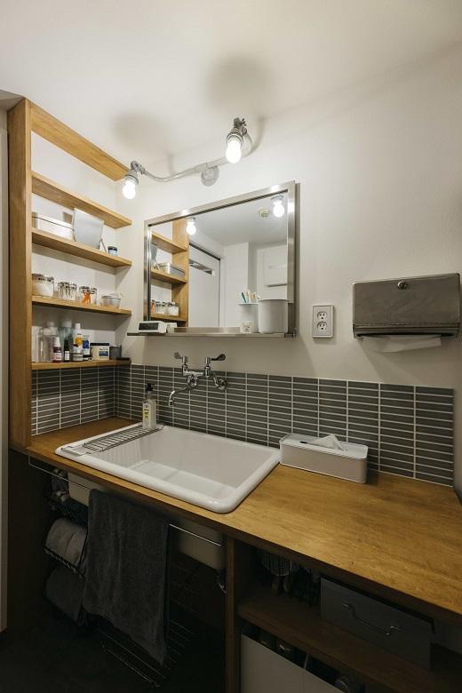 グレータイルでシャープな印象に仕上がった造作洗面台。深くて大きい病院用シンクを採用しており、洗濯物を手洗いするときも作業しやすいです。