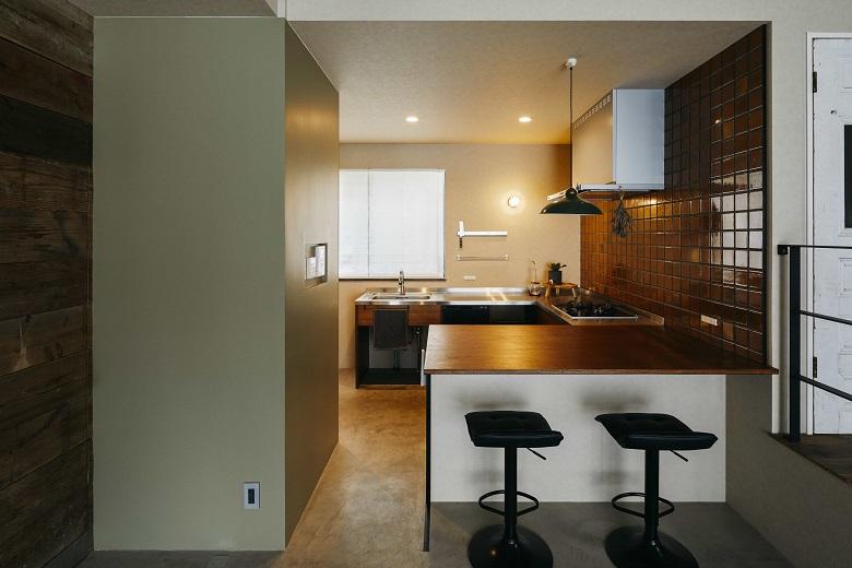 ステンレスとラワン合板で造作したこだわりのキッチン。特徴的なコの字型キッチンは、広い作業スペースを確保できるだけでなく、短い動線で作業できます。