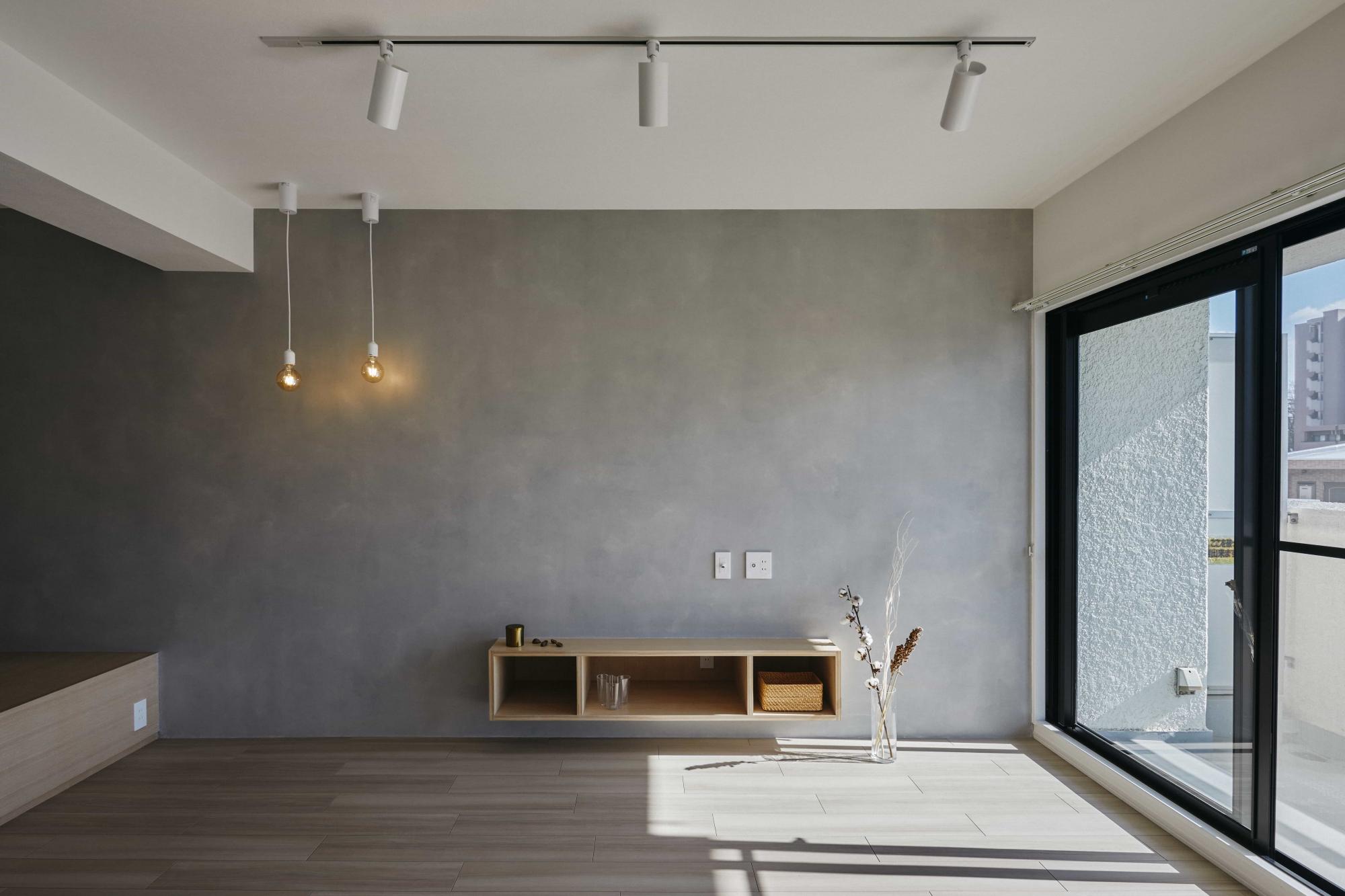 テレビボードの面はモルタル風塗料のセラミクリート塗料で仕上げ、空間のアクセントに。