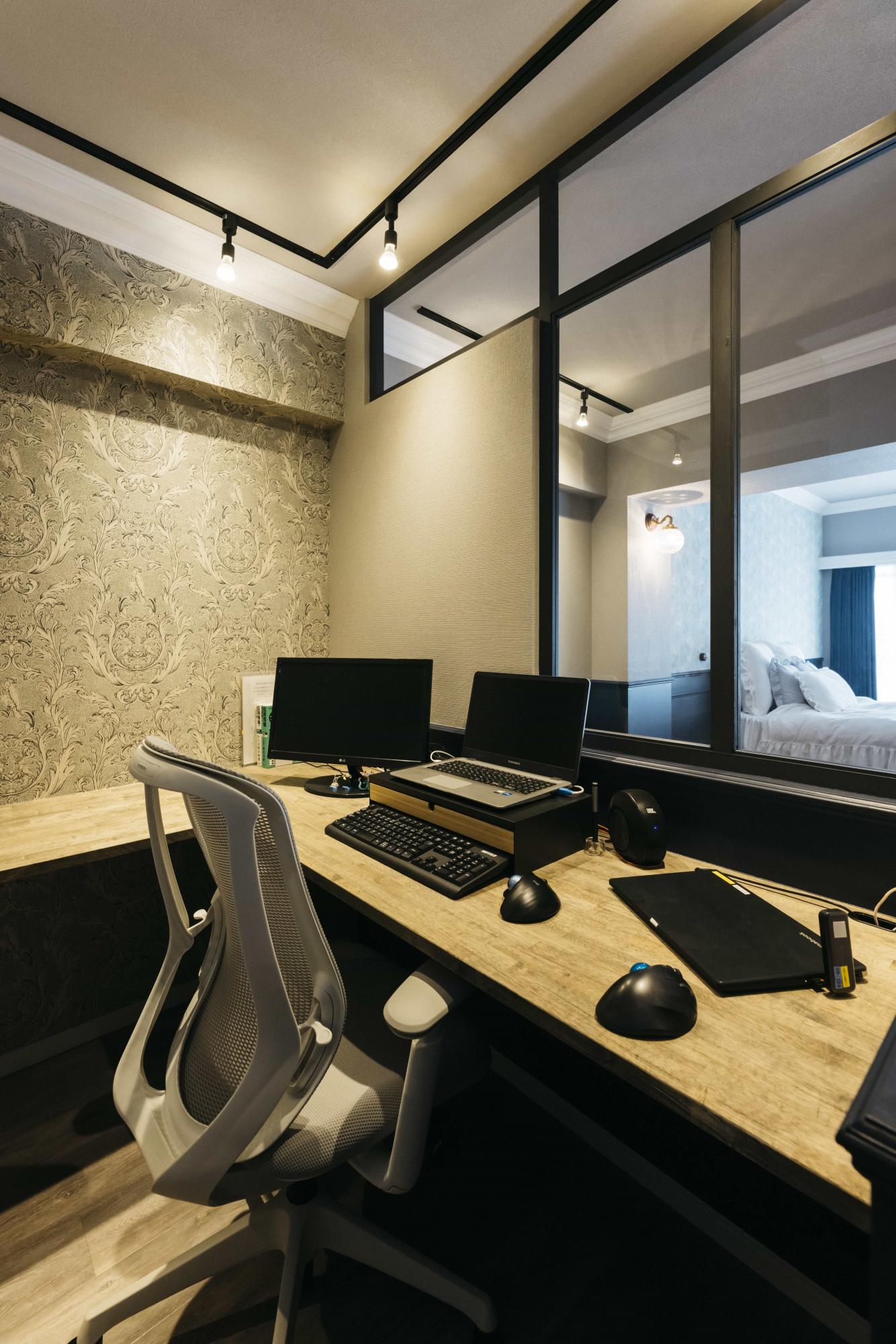 趣味の手芸もできる広々L型カウンター。大柄のアクセントクロスを施工しているのに落ち着きのあるシックな空間に仕上がっています。