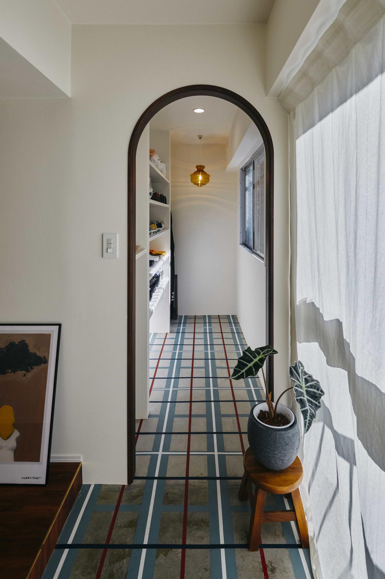 チェック柄をペイントした玄関土間。床にラインが入ることで空間に奥行きも出てより広く見えます。