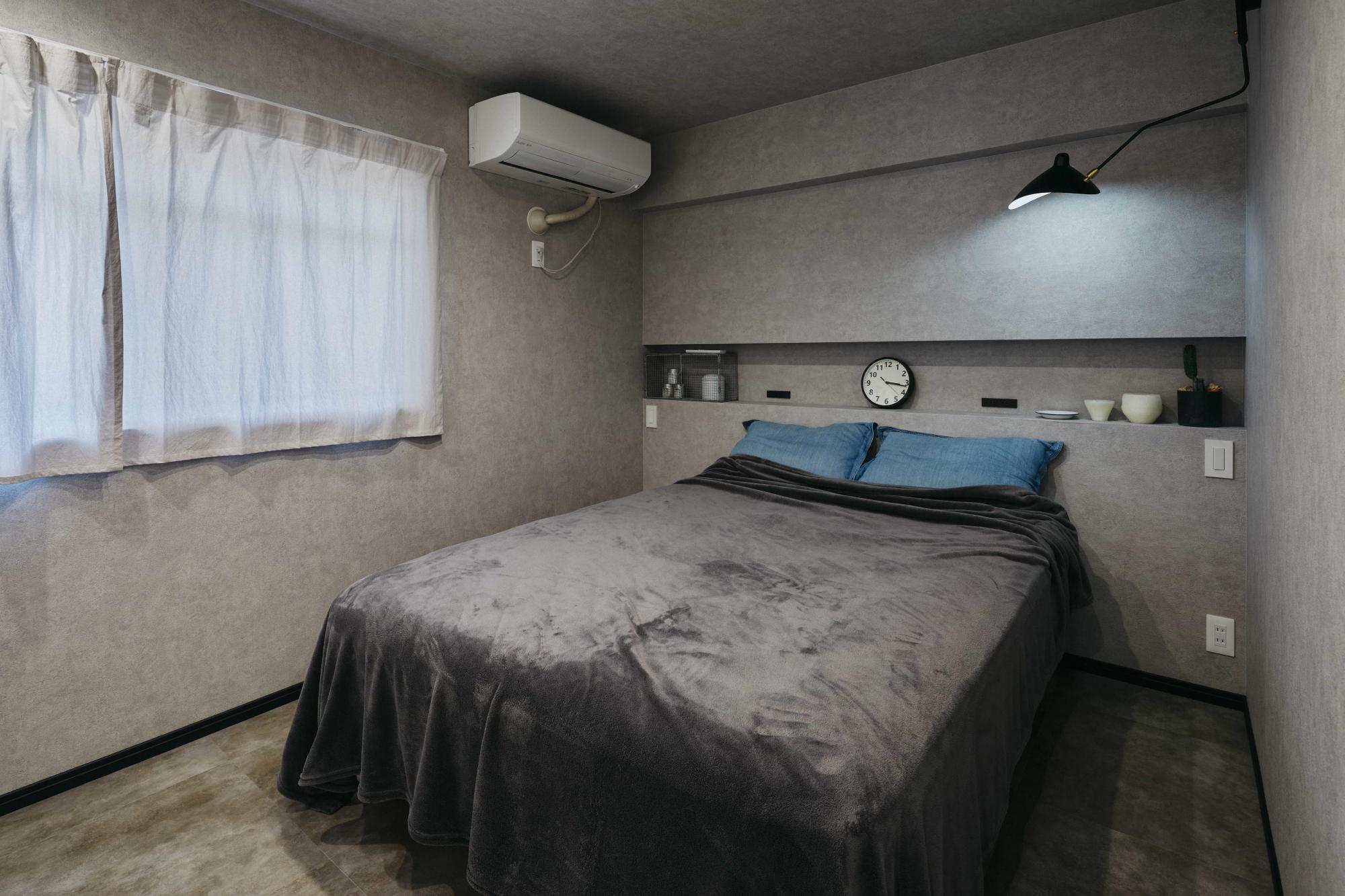 寝室はコンクリートのような質感の壁紙を使用し、シックで落ち着きがある雰囲気を演出。
