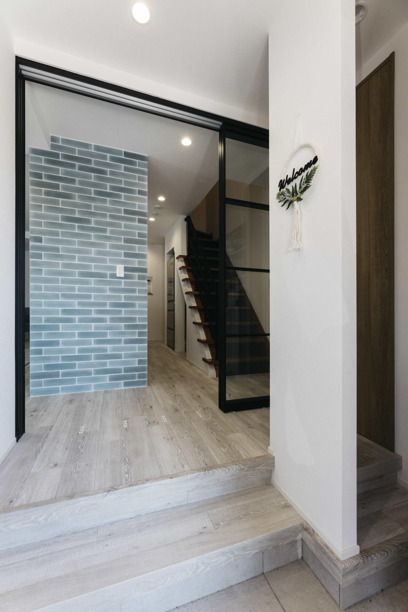 玄関から見えるキッチンの袖壁のアクセントタイルが印象的です。