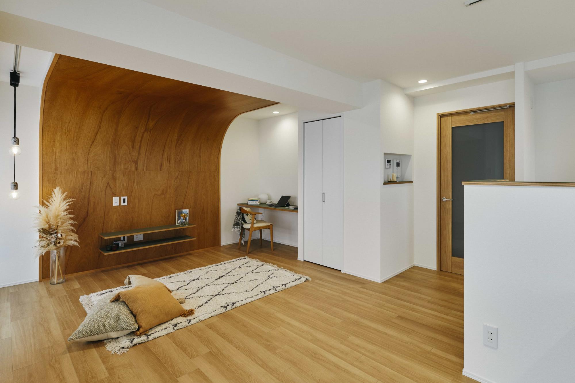 R壁が印象的なリビング。ラワン合板の大きな木目がLDKを優しく包み込み、安らぎ空間を実現しています。