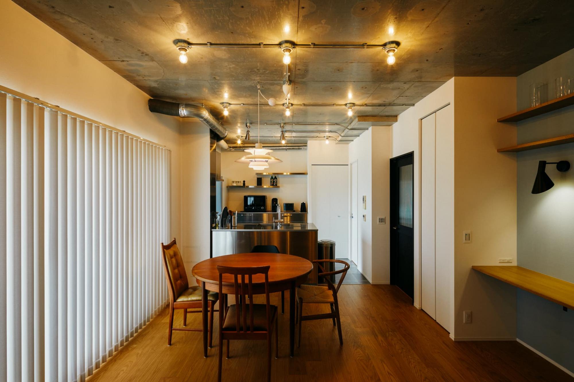 ベースの照明器具は裸電球にすることで天井面をスッキリとさせ、ダイニングのペンダントライトを際立たせています。