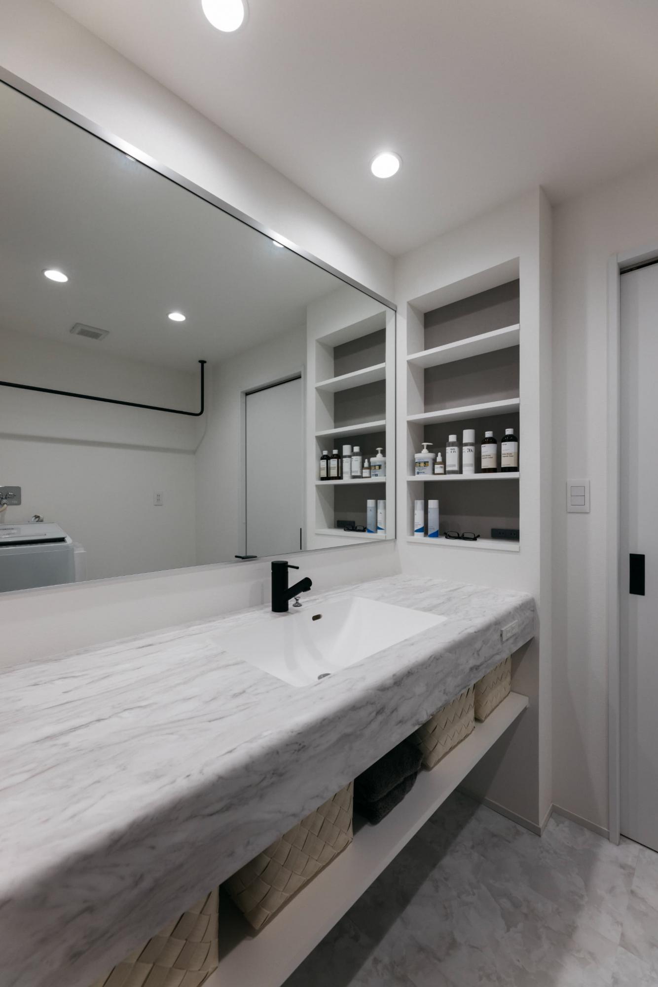 洗面脱衣室の床材は大理石調のフロアタイルを。造作の洗面台も床材と同様に大理石柄にしてホテルライクな雰囲気に仕上げています。