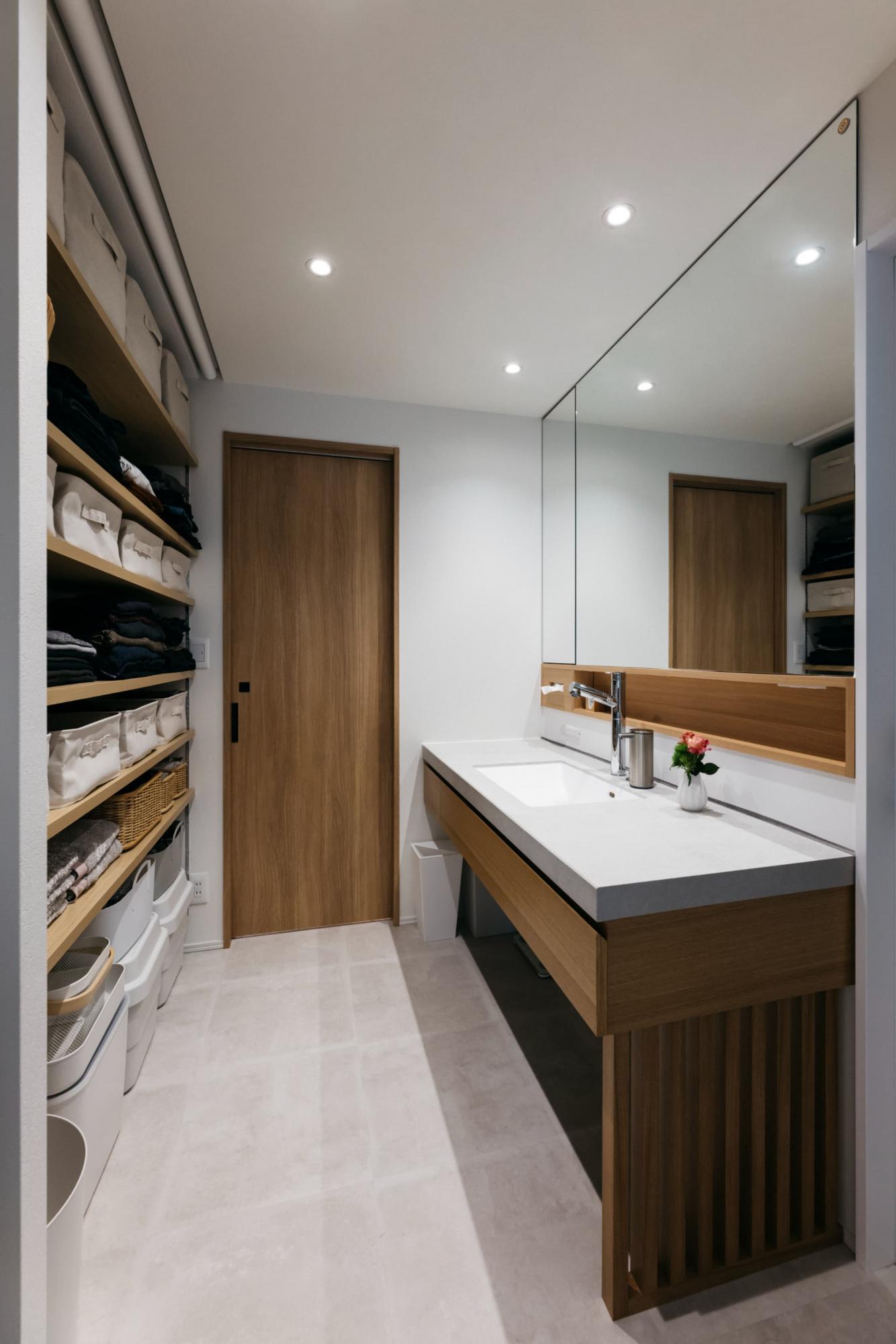 洗面台背面には収納棚と洗濯機置き場を計画しており、来客の際はロールスクリーンで目隠しが出来ます。