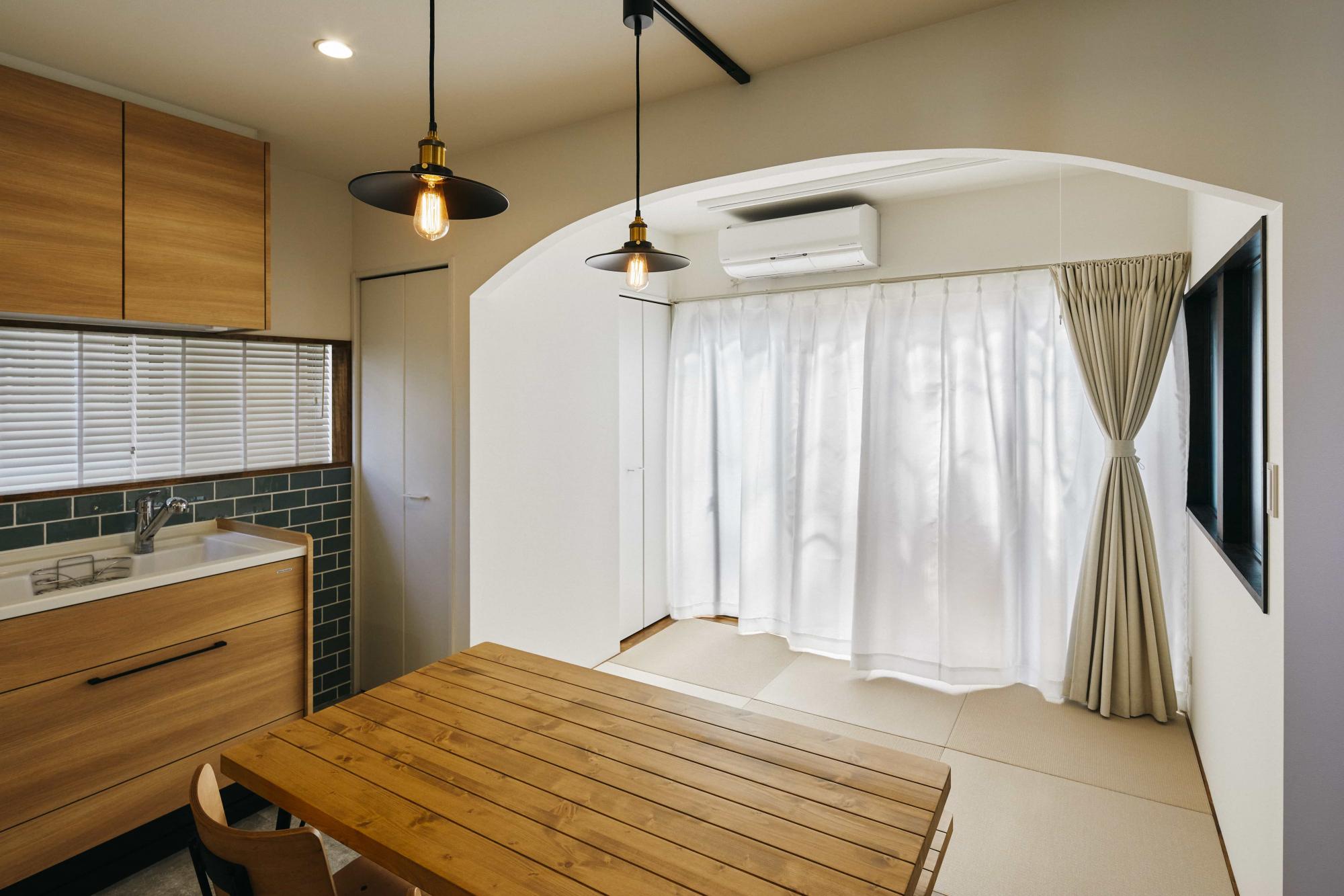 リビングから和室に繋がる入口はアーチの開口に。畳スペースは物干し金物を取り付けることで、室内干し場としても活用できるようにしています。