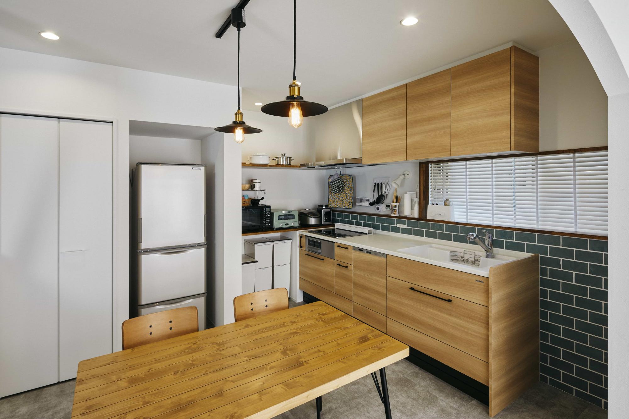 壁付けキッチンにすることでリビングダイニングを広く取ることができ、キッチン壁面に施したタイルが印象的に見える仕上がりになります。