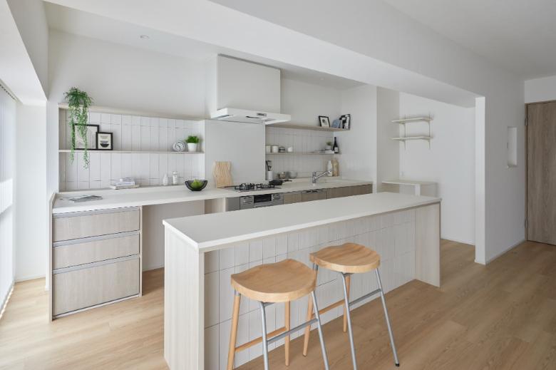 ロングキッチンの手前には造作キッチンカウンターを設置。食事をとったり料理をしながら作業することができるだけでなく、キッチンが丸見えにならないように目隠しの効果も果たします。