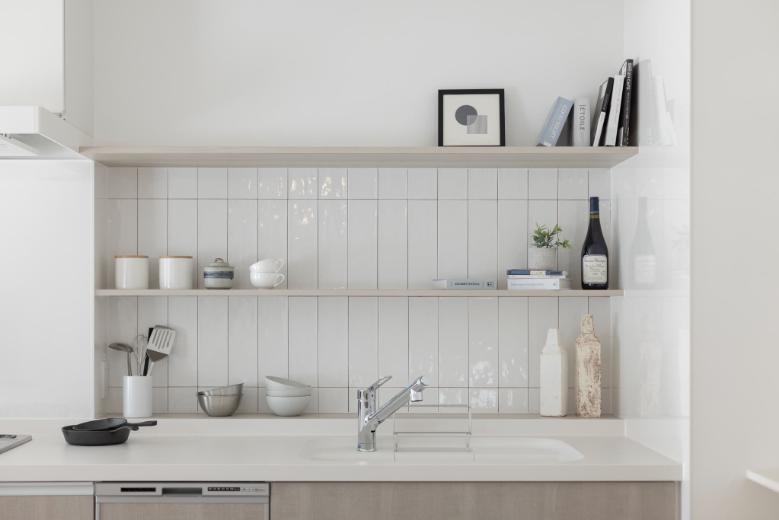 汚れやすいキッチン周りは掃除がしやすいようにクロスではなく、キッチンパネルとタイルで仕上げています。調理器具や食器を収納できる棚もあり、キッチン周りが綺麗に片付きます。