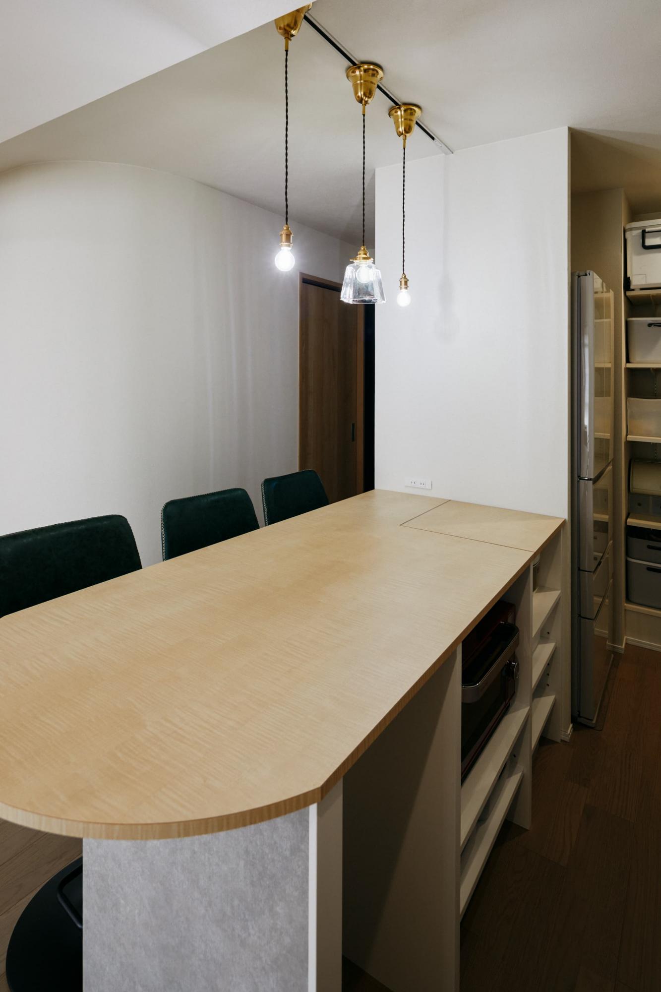 造作のキッチンカウンターはダイニングテーブルとして使うだけでなく、家電収納の役割も担っています。