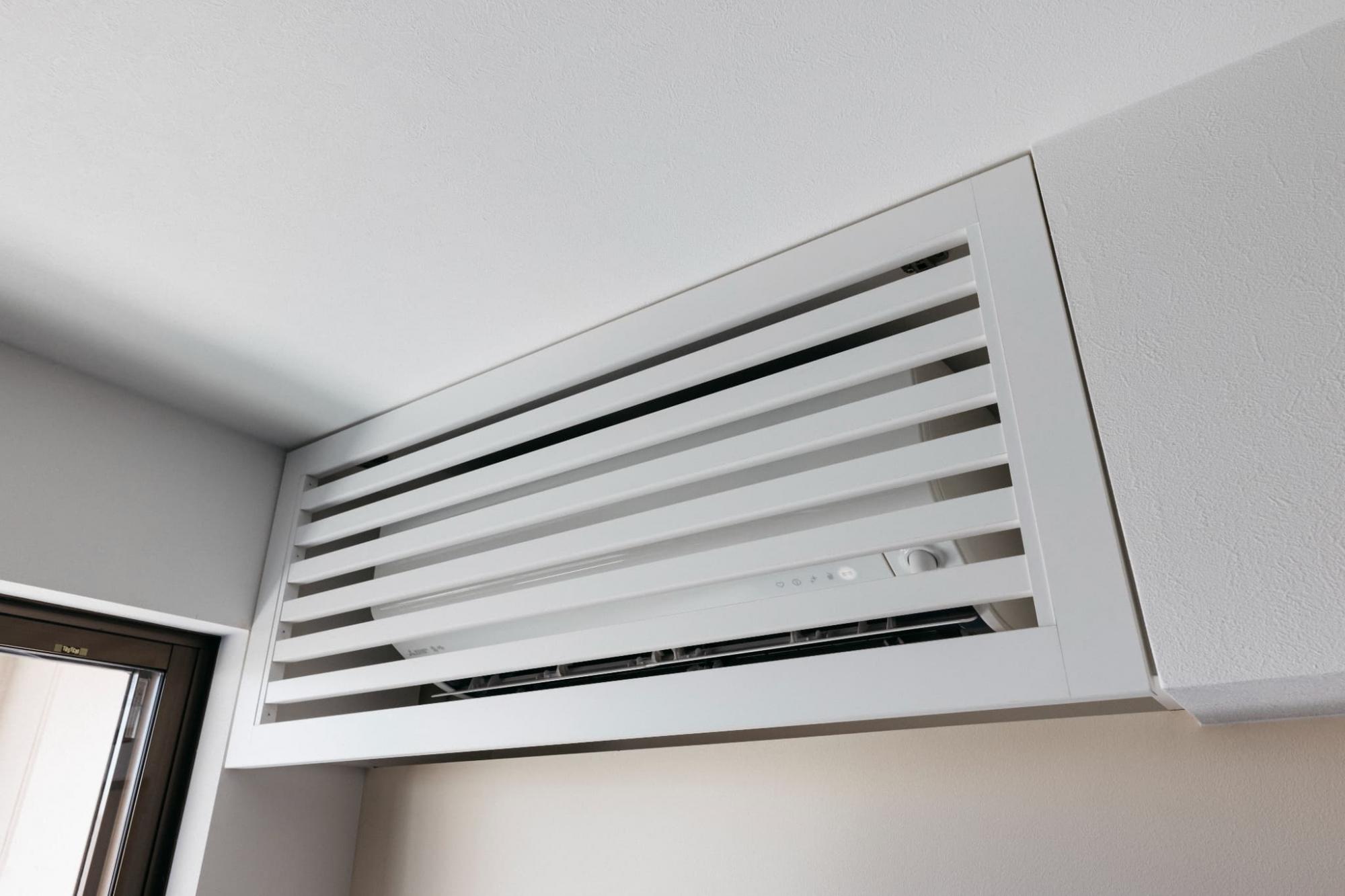 生活感が出やすいエアコンは、造作垂れ壁に馴染むような隠し扉をつけて格納しました。