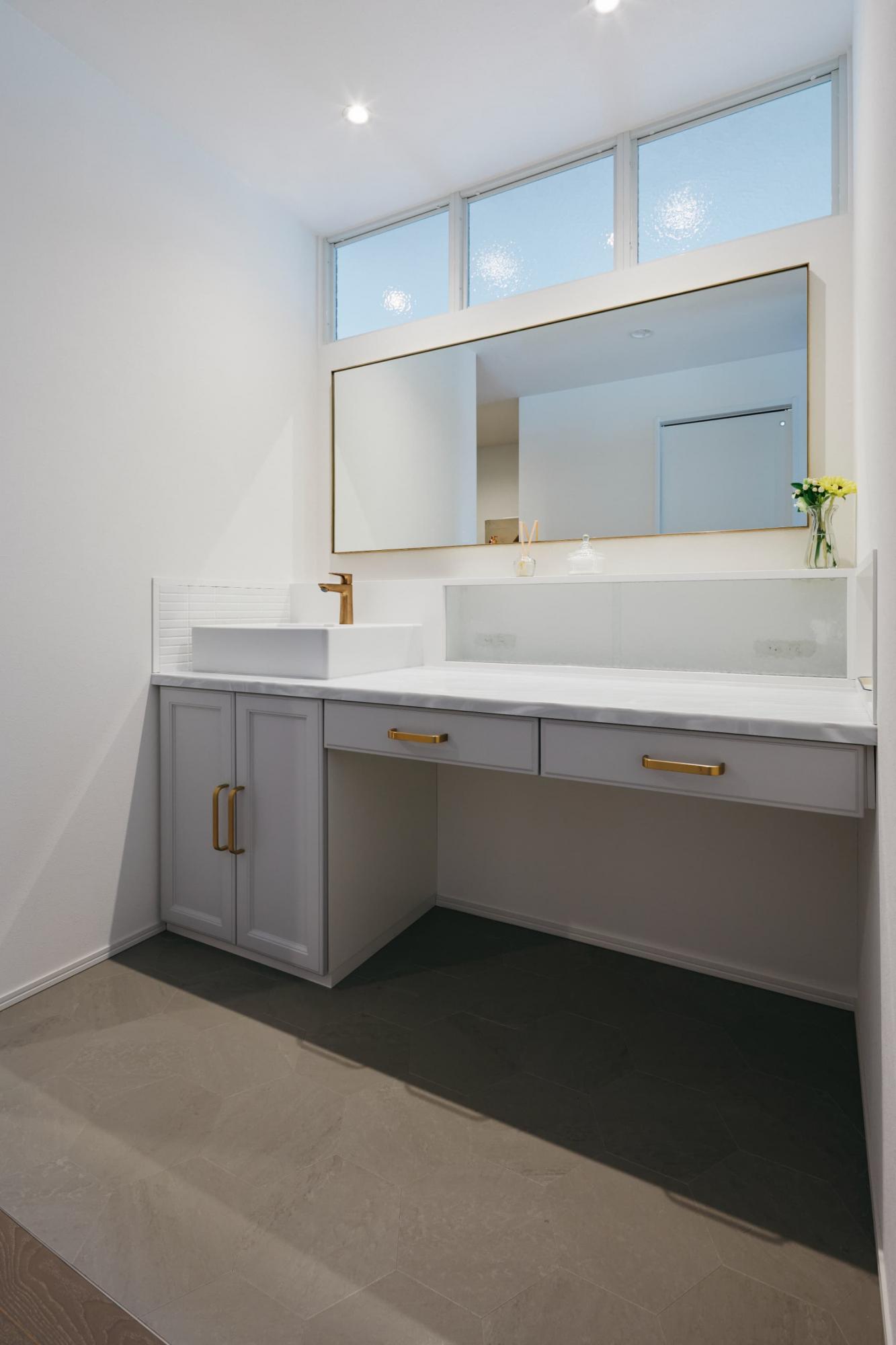 幅170㎝の大型洗面台を造作。間取りの中央に配置した洗面室に光を入れるために、主寝室と隣接した壁にアンティークガラスの室内窓を設置しました。