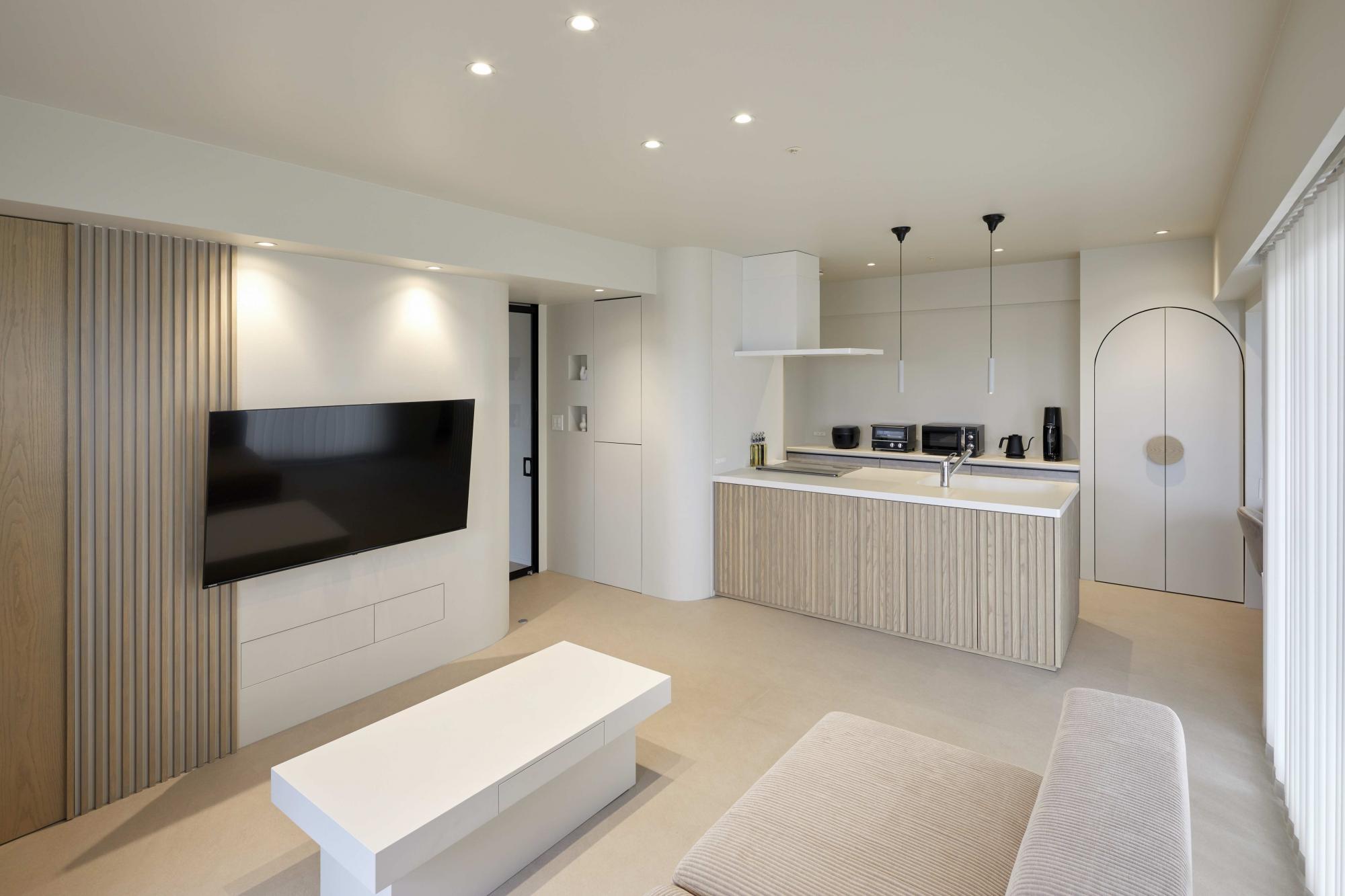 TV面のルーバーはホワイトアッシュの無垢材で施工し、キッチンの腰壁と素材を合わせて全体的な統一感を出しました。