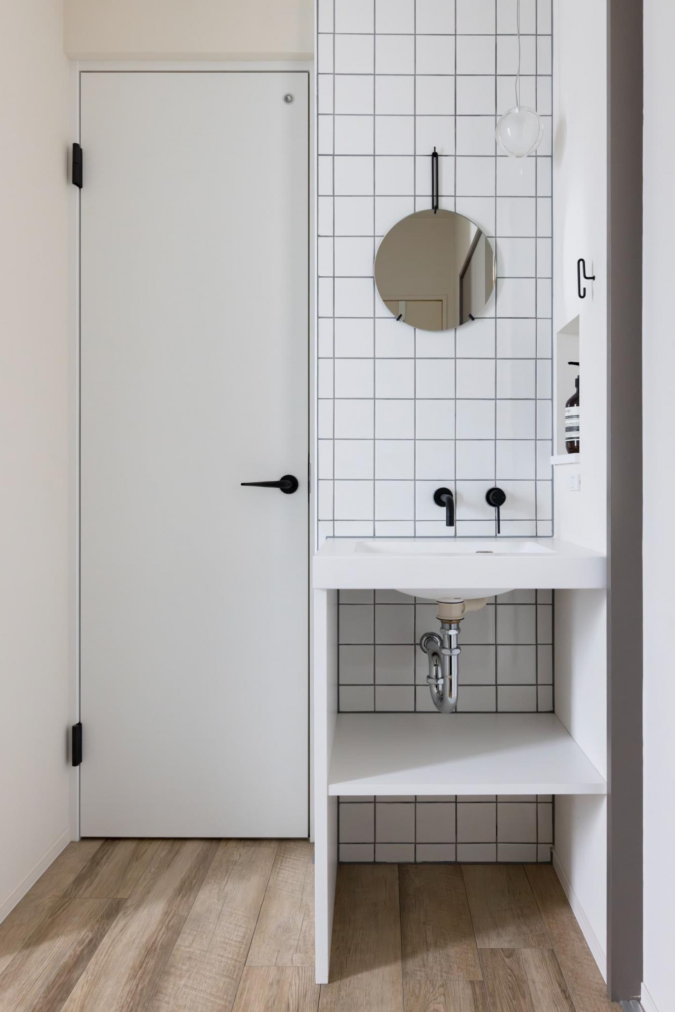 施主様のこだわりの照明器具が映えるように、シンプルモダンな雰囲気に仕上げた玄関横の造作洗面台。