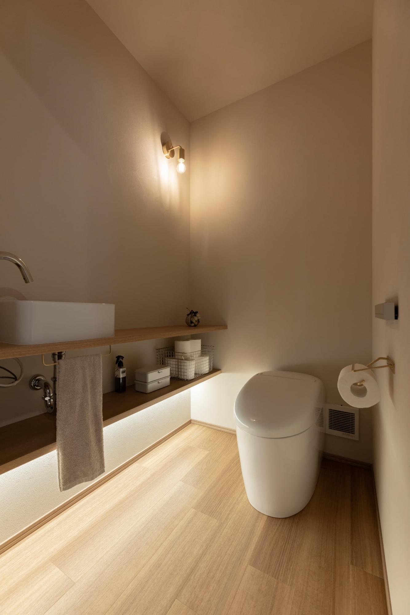 通常のトイレよりも幅や奥行きを広く計画しているため、ゆとりのある快適な空間になりました。薄暗い空間を明るくするため、棚板の下部に間接照明を仕込んでいます。