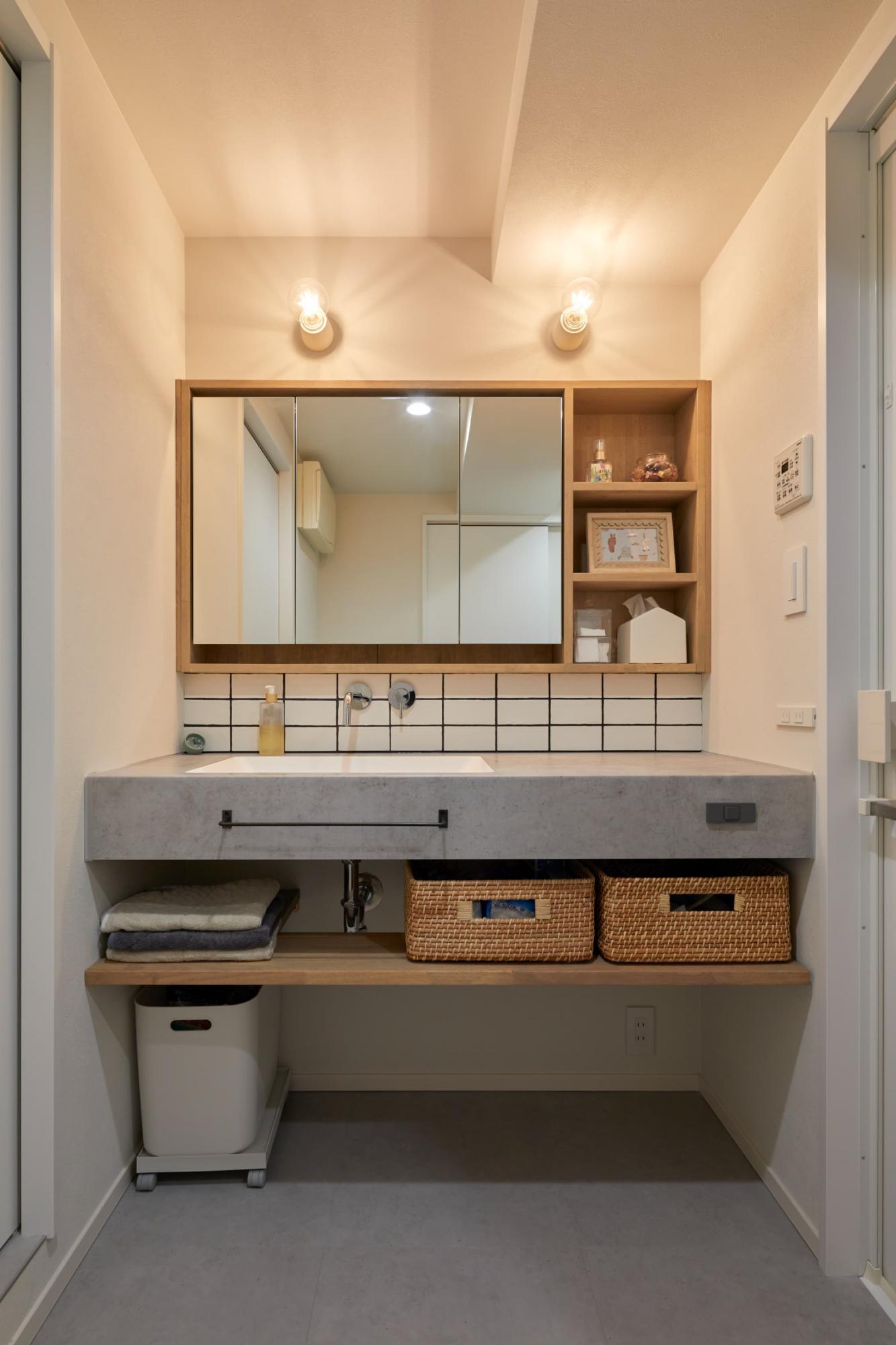 既製品のミラー収納をオーク材の造作収納で囲うことで、壁一面に収納スペースが生まれます。