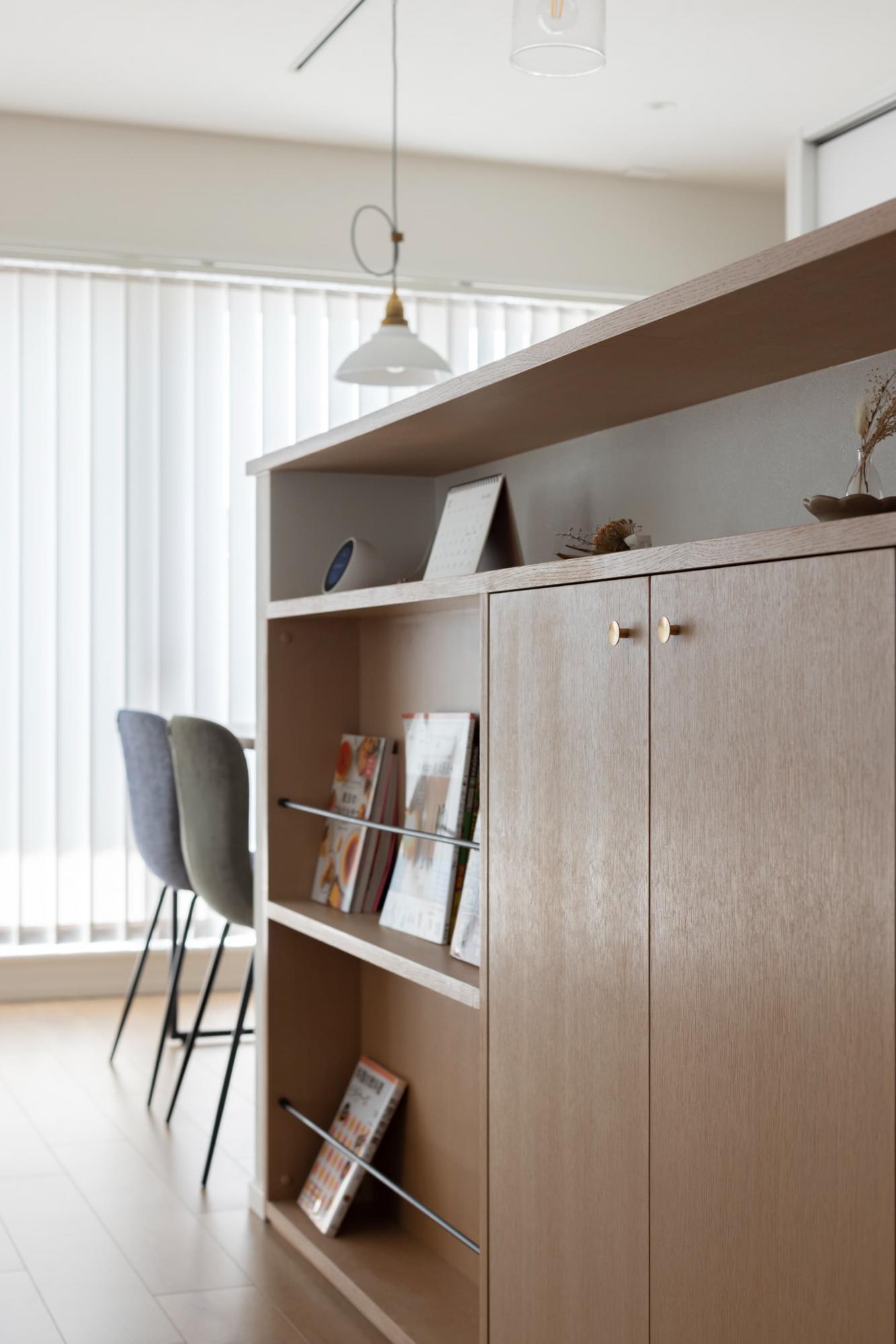 キッチン腰壁も造作で製作。隠す収納とあわせて計画した雑誌入れは、欲しい本が取り出しやすいうえに、お気に入りの本の表紙を見せるように飾れます。