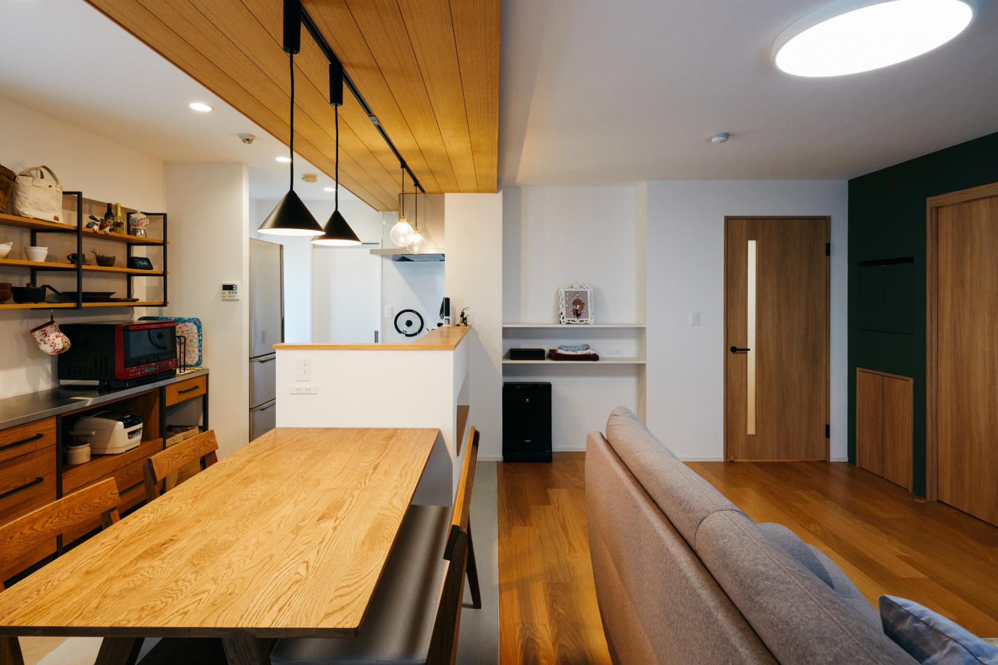 床と折り下げ天井のラインを揃えることで、まるで空間が逆転しているような錯覚を覚え、食卓とくつろぎ空間をさりげなく区切っています。