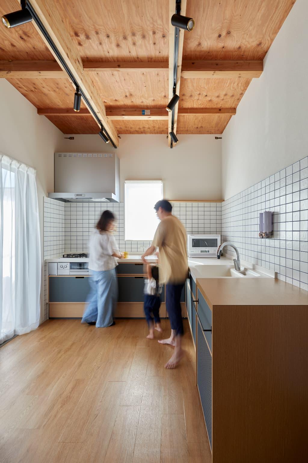 デザイン性を高めつつコストを抑えるために、メーカーキッチンの面材だけを青色のリノリウムに交換するというアイデア。