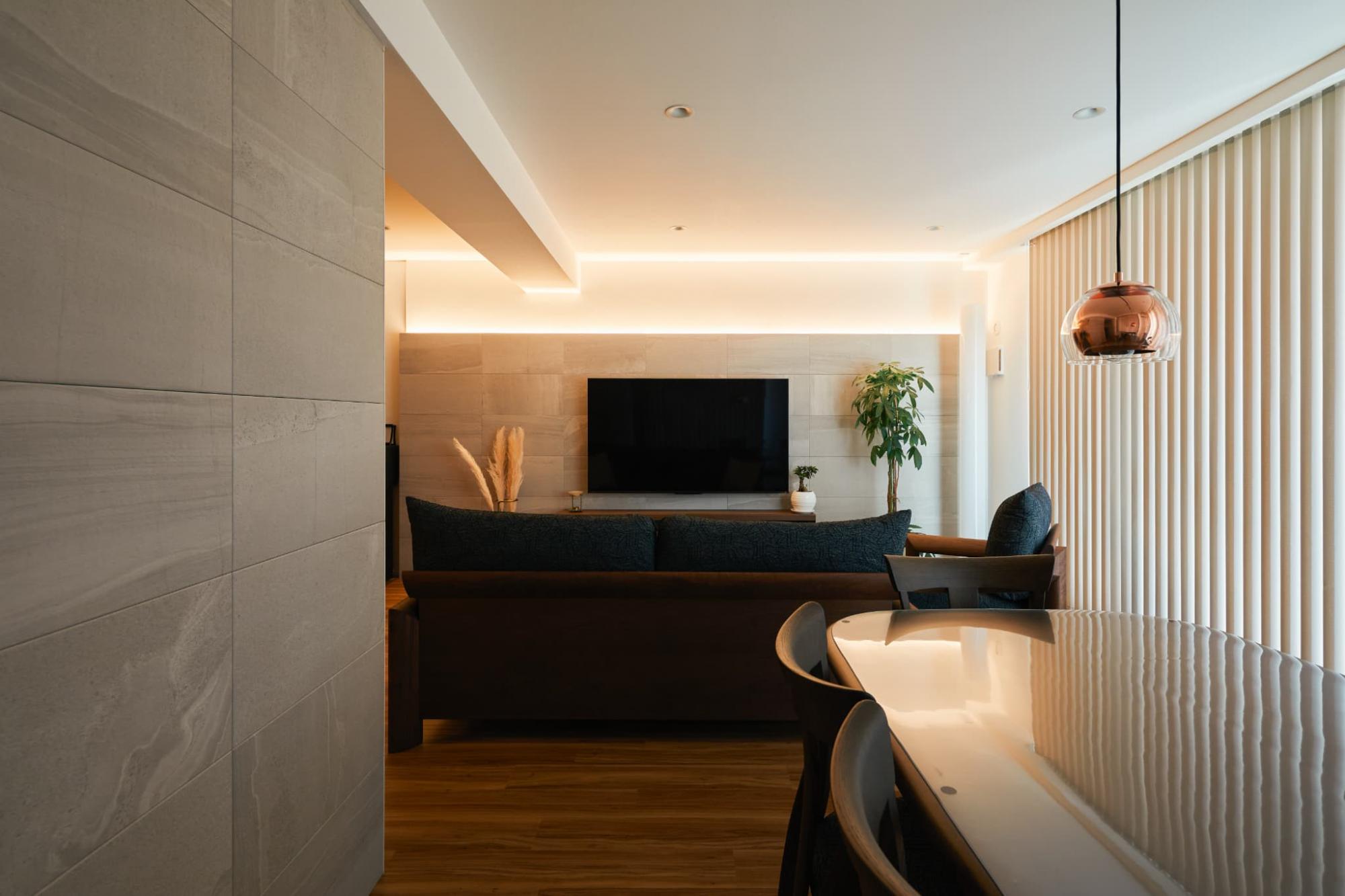 TV背面とキッチン横の壁面には、石目柄のエコカラットを貼りました。間接照明も相まって、高級感が漂います。