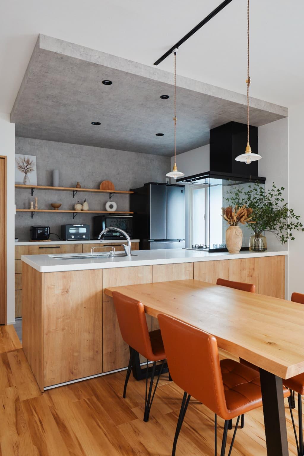 天井からキッチン背面の壁にかけて、同じモルタル調のデザインクロスで仕上げています。