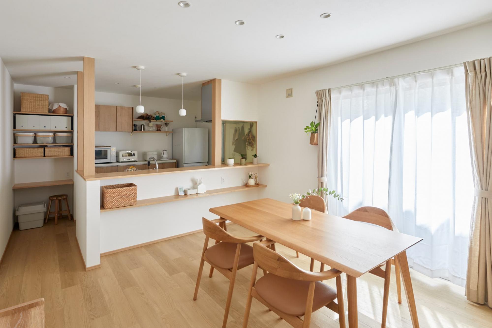 床材とカウンター、柱、キッチンを同系色でそろえた、ナチュラルな空間。