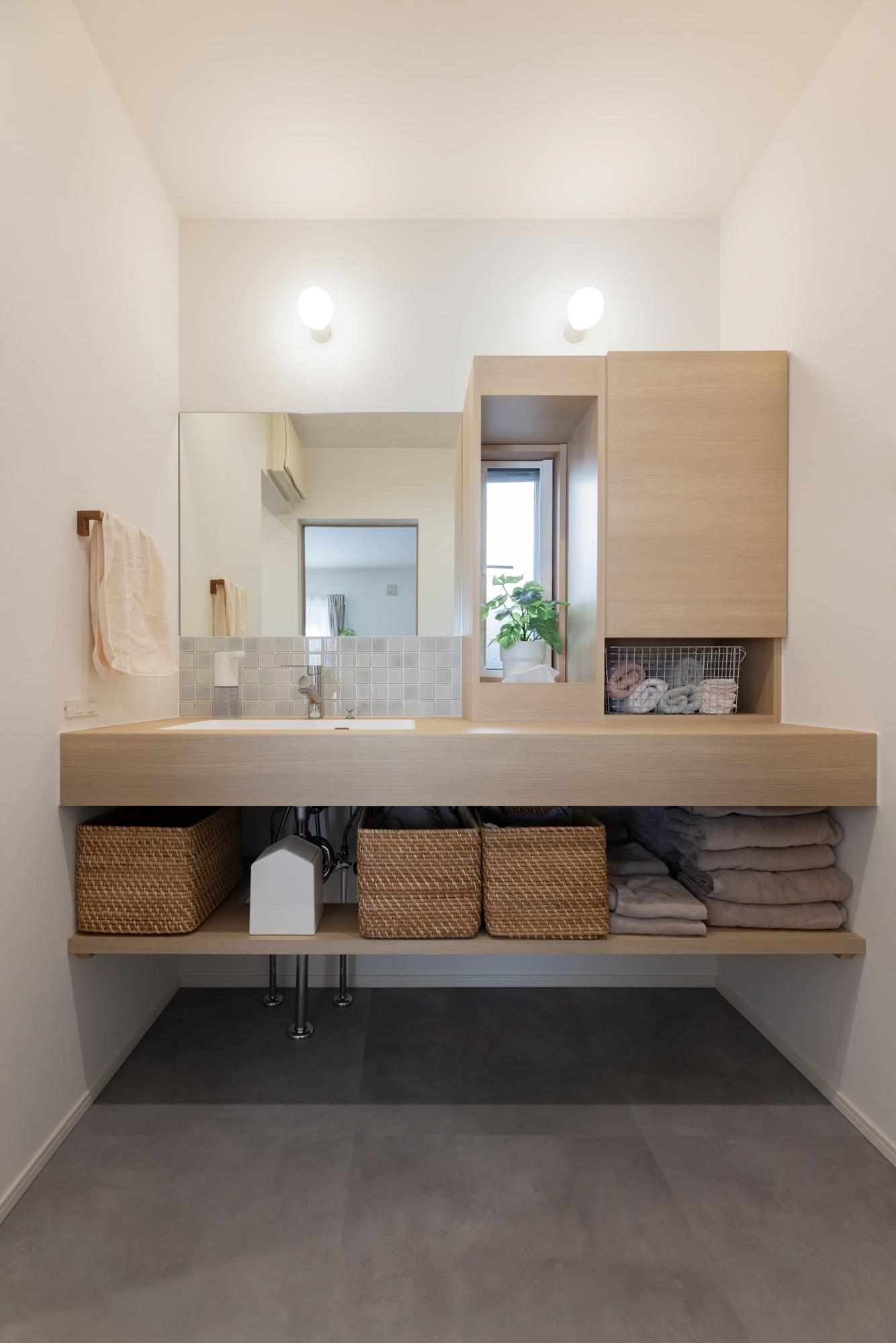 アイカ工業のメラミンカウンターと収納を組み合わせた造作洗面台。既設の窓を活かした明るい空間です。