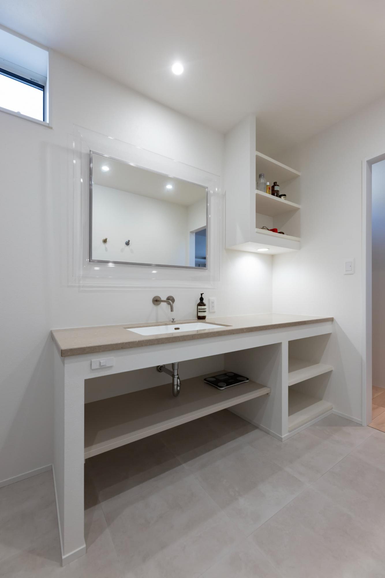 造作洗面台は、天板にフィオレストーンの大理石、鏡にはトーヨーキッチンのミラーを使って、高級感のある仕上がりに。