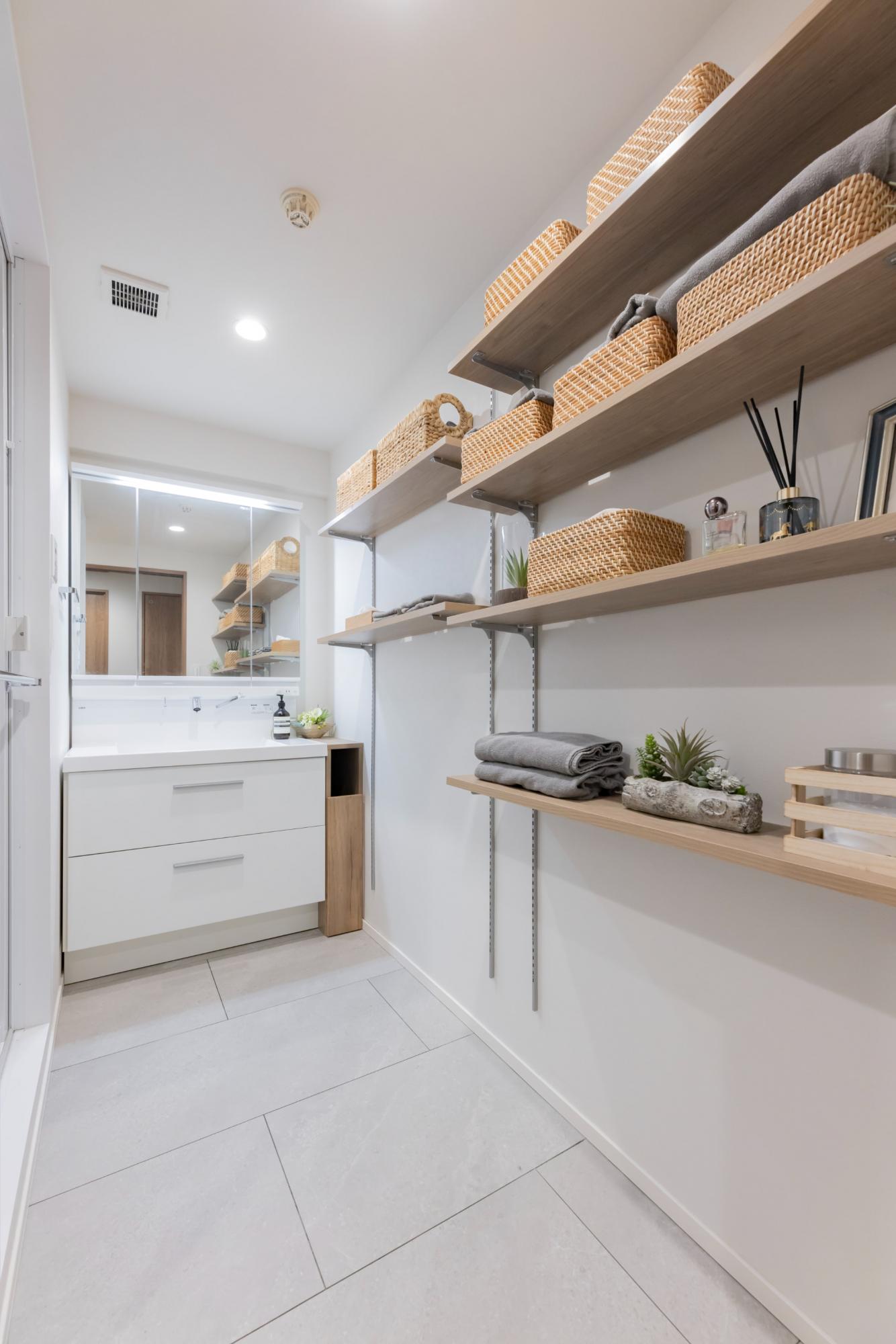 洗面室は広く明るい空間へ。棚板を設置して、収納量も増やしています。