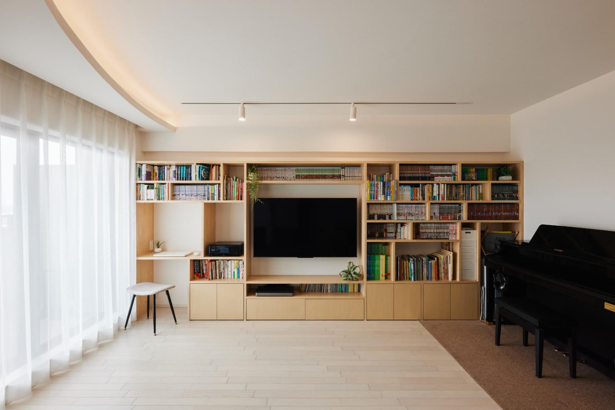 壁面に大きな造作本棚を計画。棚をランダムに配置したことで漫画や雑誌など様々な形に対応しています。