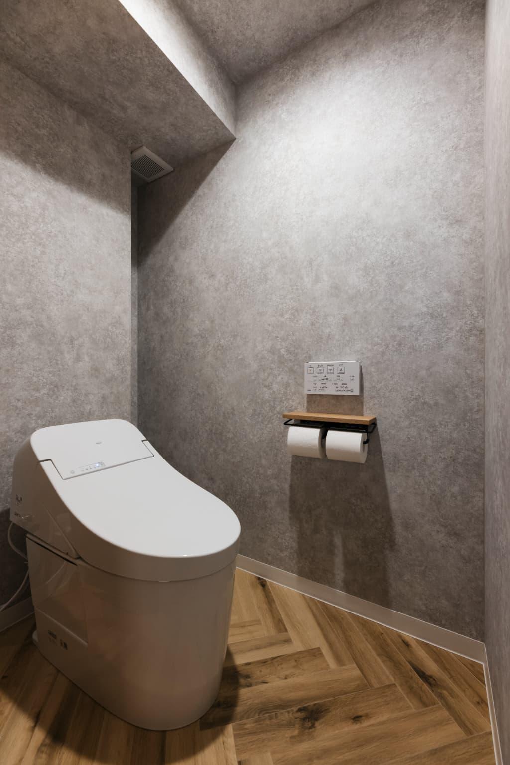 トイレの床はヘリンボーンに。グレークロスでシックに仕上げています。