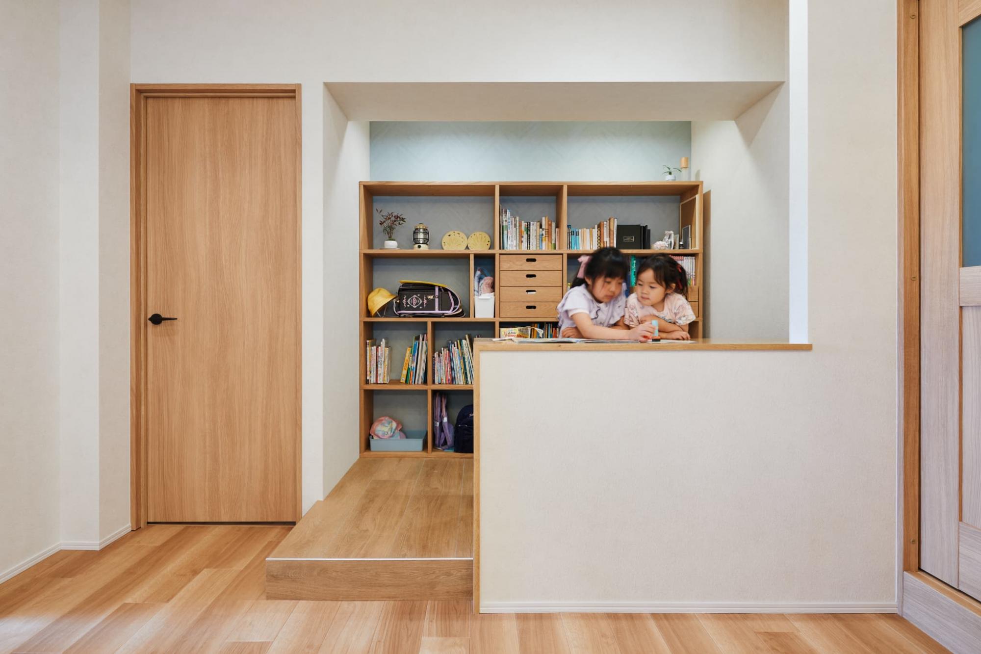 リビング内に小上がりをつくり、ワークスペースへ。段差をつけることで、壁をつくらず広く見せたまま空間を区切っています。