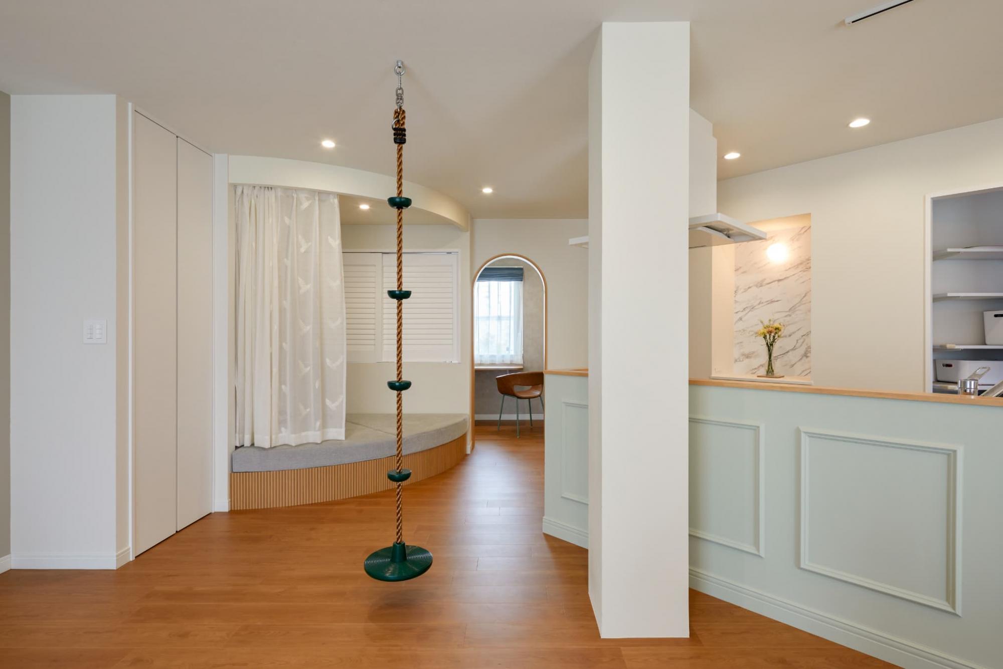 アーチ開口の向こうには洗面とワークスペースを配置。奥様が化粧をしている際も家族の気配が感じられます。