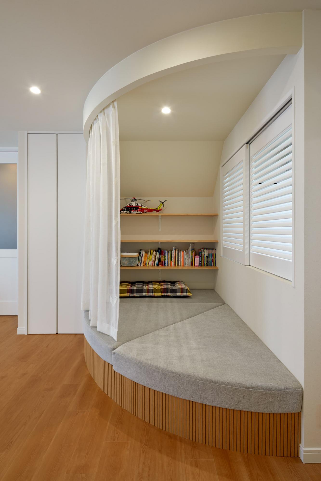 頭上にはRの垂れ壁を作り、レースのカーテンで仕切れるように設計。ヌックに座りカーテンを閉めれば、自分だけの簡易的な個室空間を作ることができます。