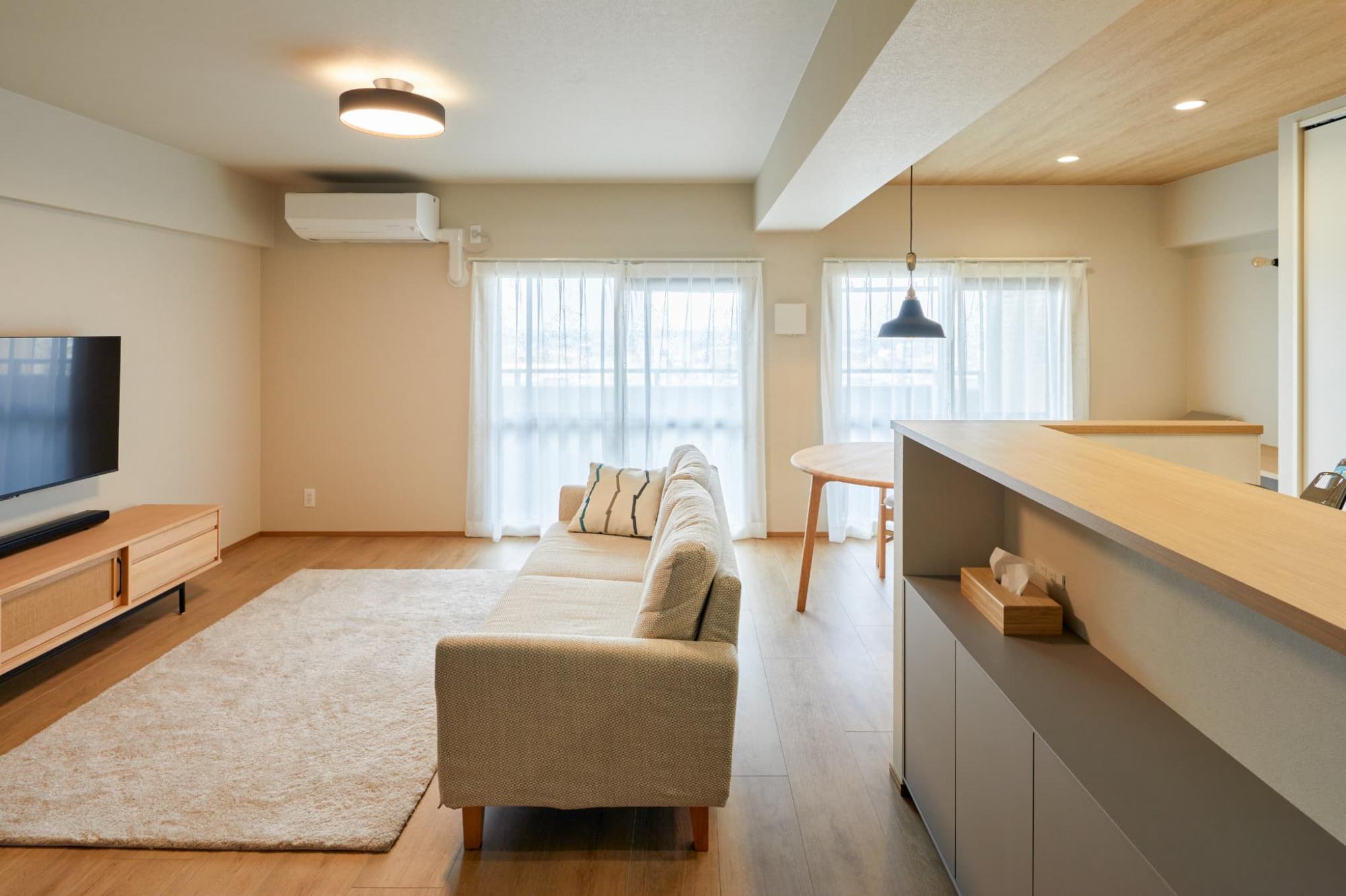 天井の壁紙はリビングにベージュカラー、キッチンに木目のクロスを使用し、空間にメリハリをつけています。