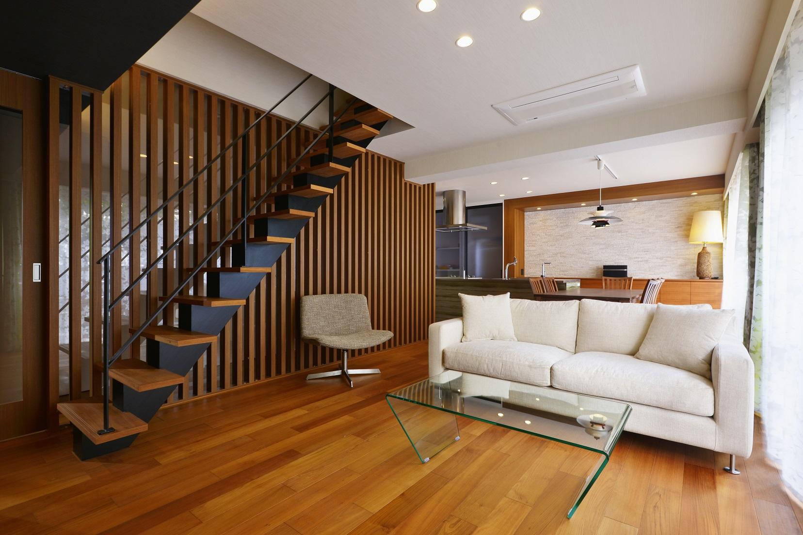 廊下は格子とアクリルパネルで仕切られていますが、アクリルパネルを通した光が
廊下にもリビングにも取り込まれています。
美しい階段がリビングのアクセントにもなっています。