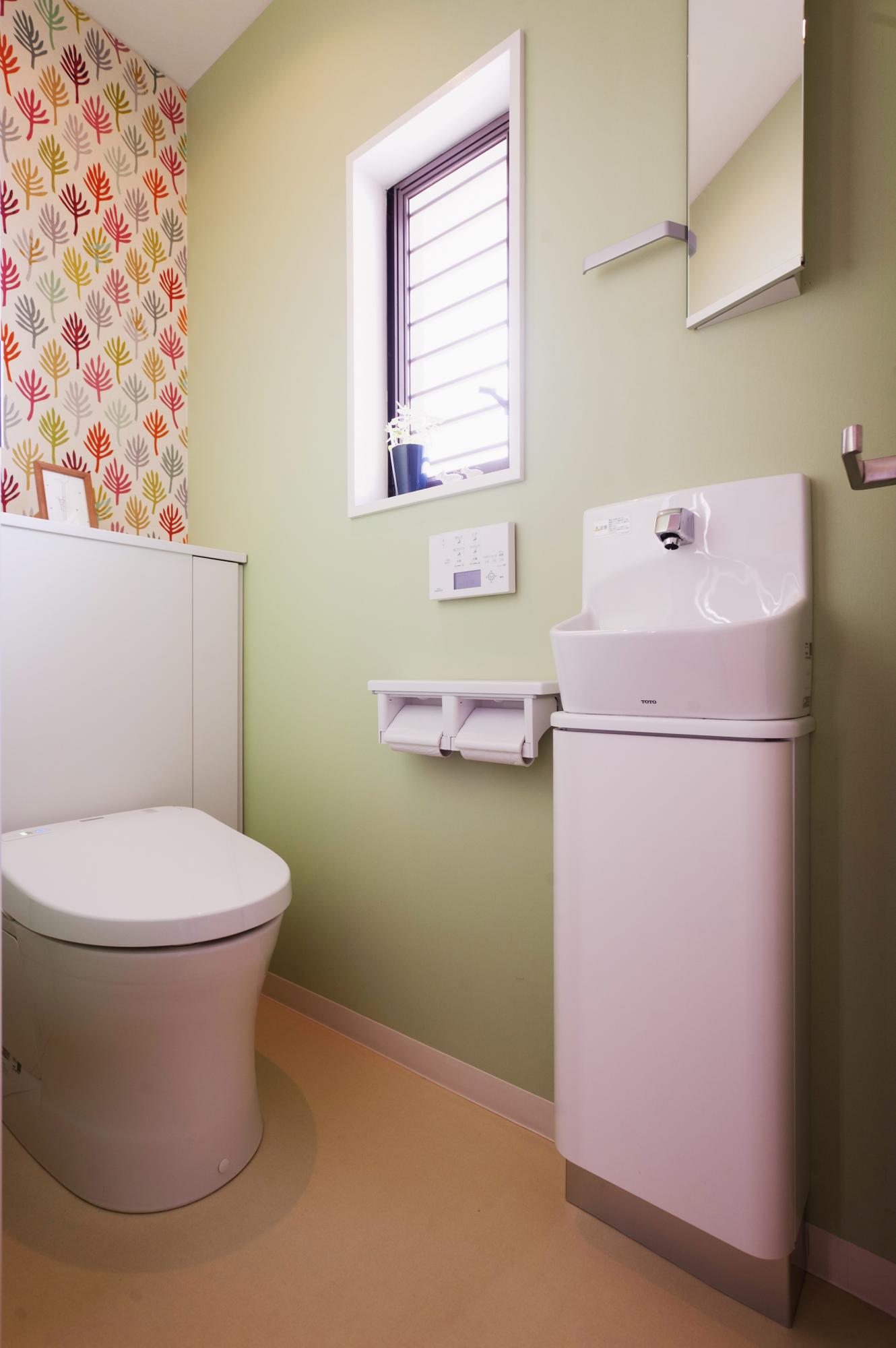 アクセントクロスで可愛らしさを演出。小さな手洗いと鏡も設置して機能的です。