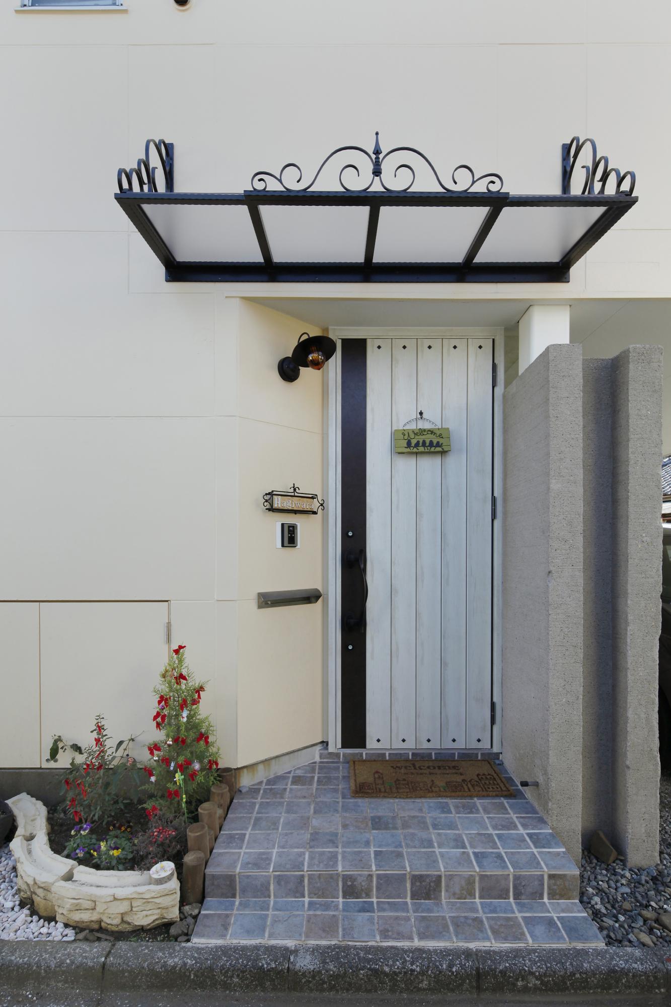 ランダムな色合のアンティークタイルと軽量で丈夫なローとアイアンの庇で
ヨーロッパテイストで仕上がった玄関です。