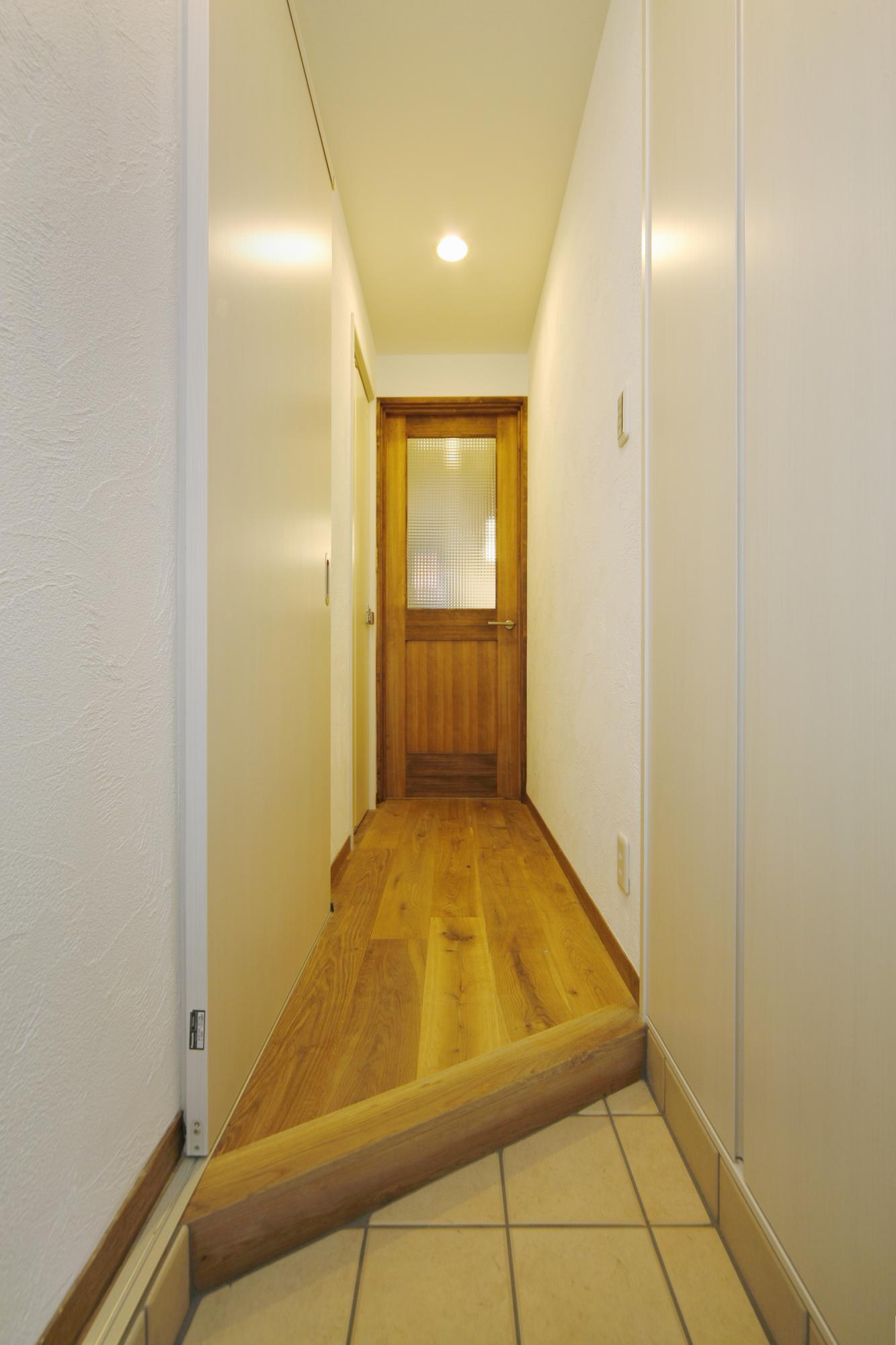 上がり框を斜めにして空間の広がりを感じさせる玄関です。下足入れは天井までの高さいっぱいに設けました。