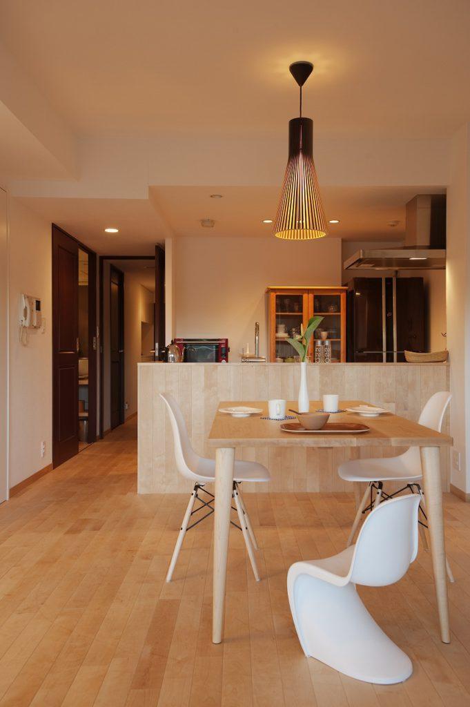 リビングとの繋がりを演出するために床のフローリングをそのまま腰壁として立ち上げ、キッチンの圧迫感を自然な存在としました。