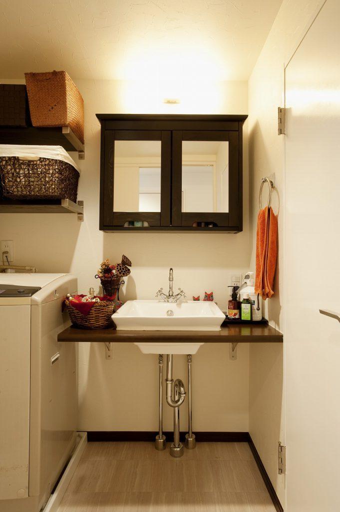 ▲こげ茶のカウンターに洗面ボウルをはめ込んだ、シンプルなデザインの造作の洗面化粧台です。IKEAのミラーキャビネット、水栓にはグローエなどこだりました。