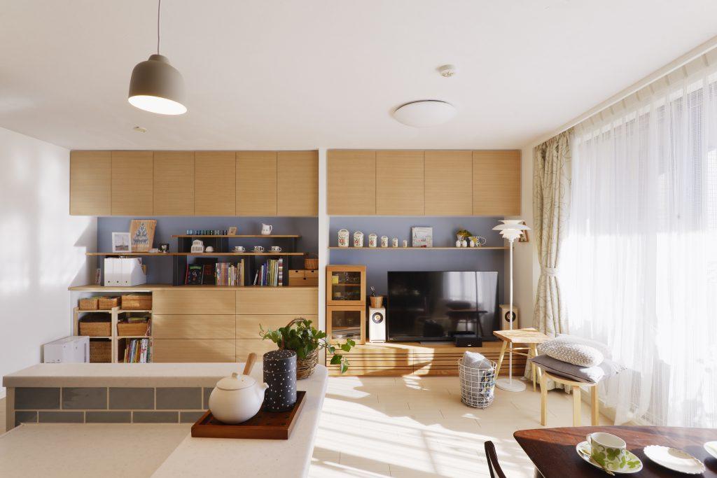 リビングには幅５メートルの壁面収納。 
フランスで見つけたお気に入りの雑貨や、思い出も一緒に並べました。
吊戸棚は収納する物によって、左右で微妙に奥行きを変えてすっきりと納まるように工夫しました。
隠すところ、オープンにするところのバランスも考えて、収納がインテリアになるような仕上がりです。