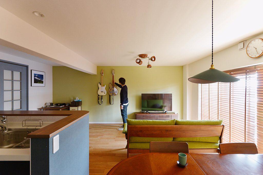 隣接していたお部屋を合わせた広々LDK。ピスタチオカラーのクロスと趣味のギターとの相性もばっちり。