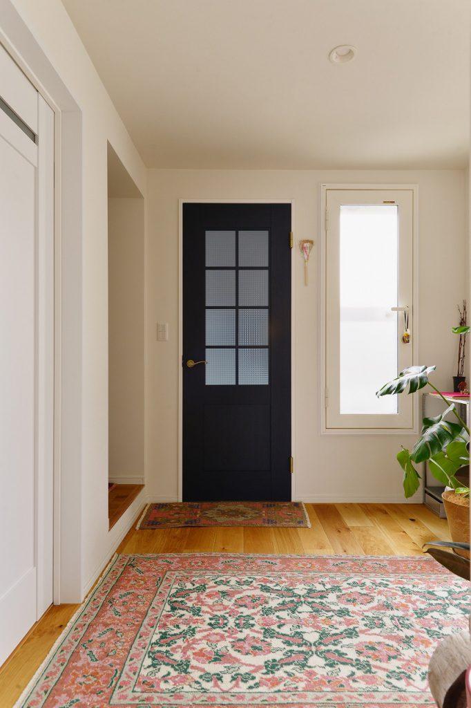 2階ホールの階段入口にはネイビーの建具を採用。1階玄関からの冷気を遮断してくれるだけでなく、空間を引き締めるアクセントにもなっています。