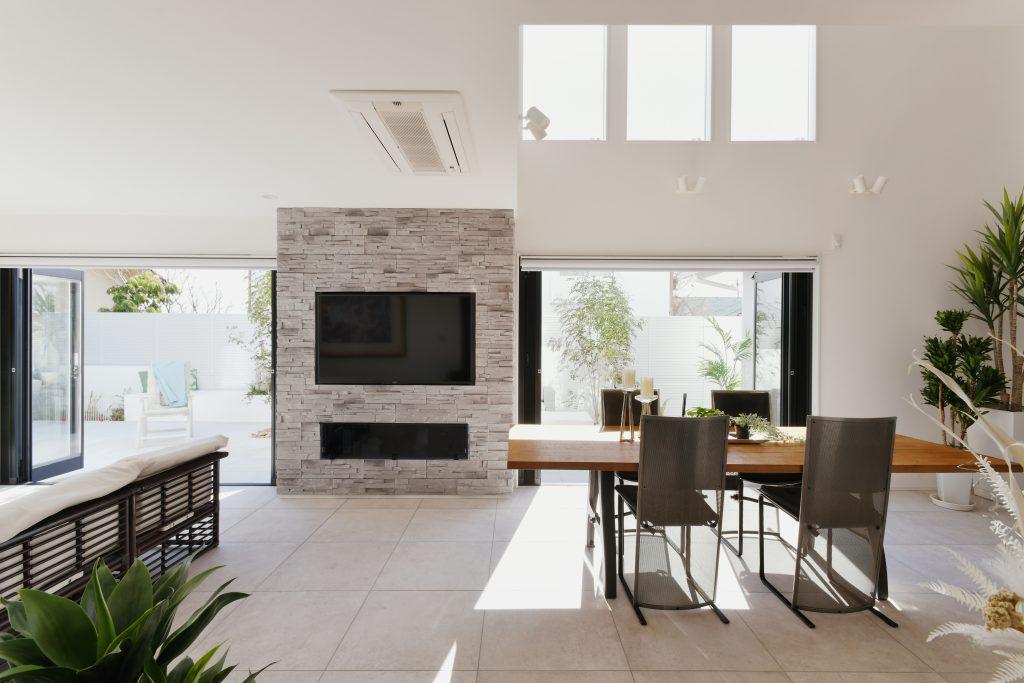 吹き抜けのおかげで日中は太陽光を感じられます。アウトドアとの繋がりも大切にリビングと庭の床レベルを合わせています。