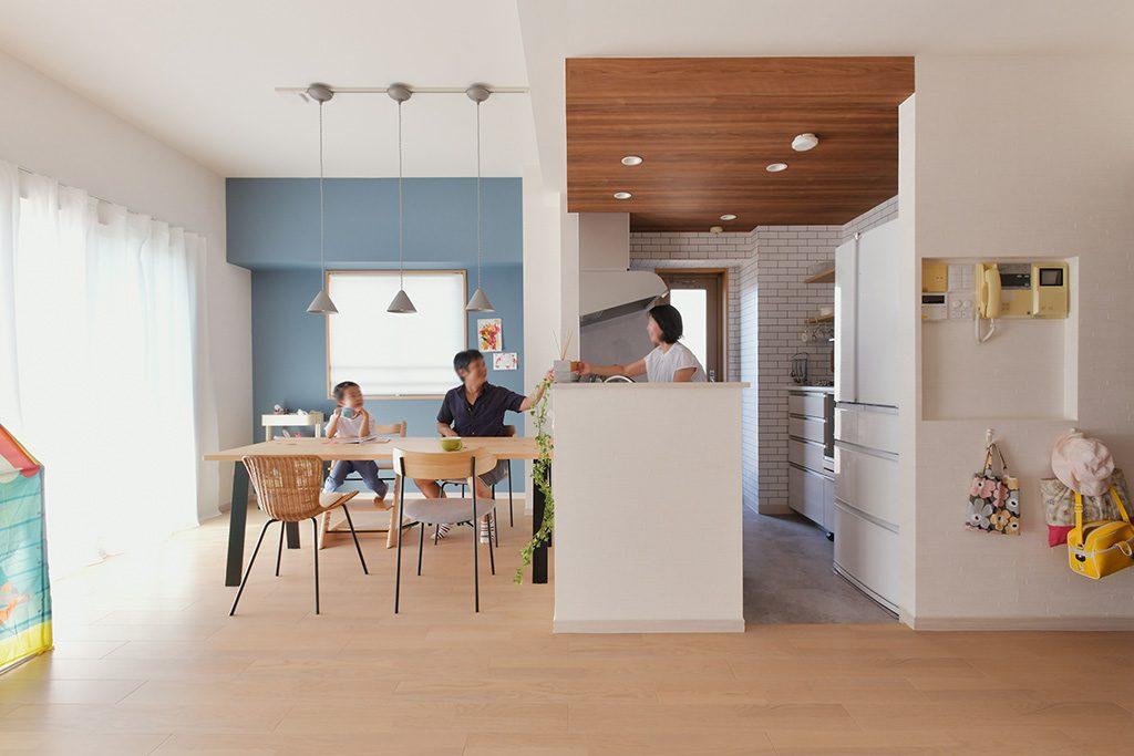 ブルーのアクセントクロスが印象的なダイニングキッチン。キッチンは元の大きさと変わりませんが、袖壁をなくして天井の色を変えることで開放的で奥行き感も感じさせてます。