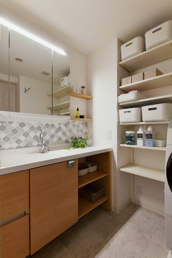 立ち上がり部分のタイルがおしゃれな収納力抜群の洗面空間。洗濯機と洗面台の位置を入替えることで広々快適な空間になりました。