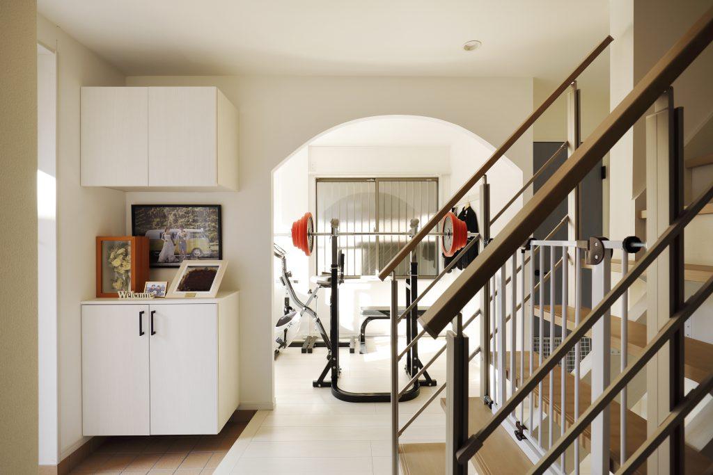 写真正面は以前DKだったところをアールの下がり壁で仕切って今は趣味のお部屋。1階全体がワンルームのように使えます。オープン階段からは上階からの光が降り注ぎます。